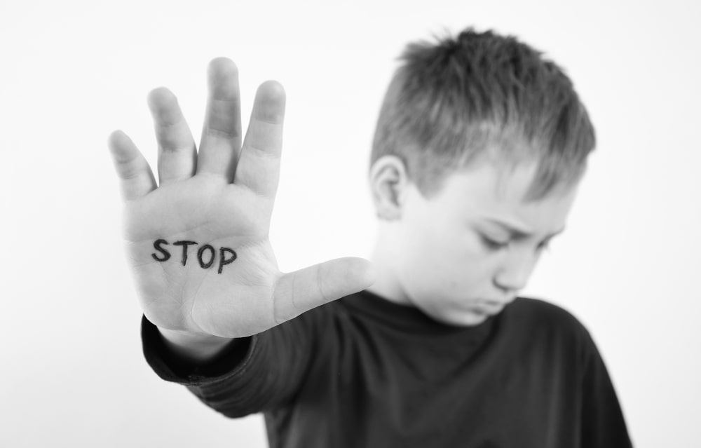 Small boy covering his face, representing child sexual abuse material cases in Canada