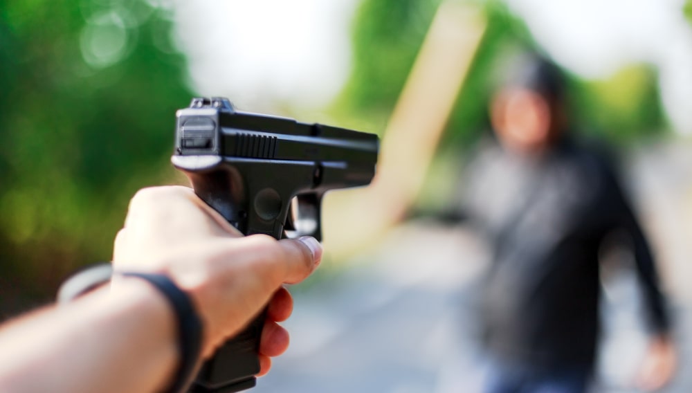 An ndividual aiming a firearm at an aggressor, illustrating self-defence in Canadian manslaughter cases