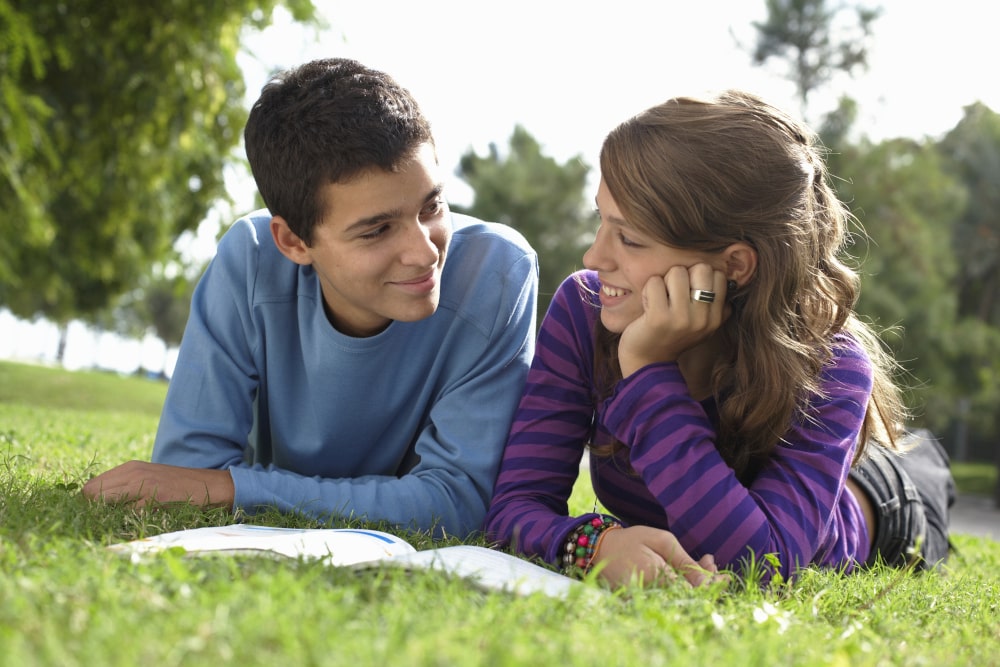 What is the Age of Consent in Canada: Teenage couple lying on grass