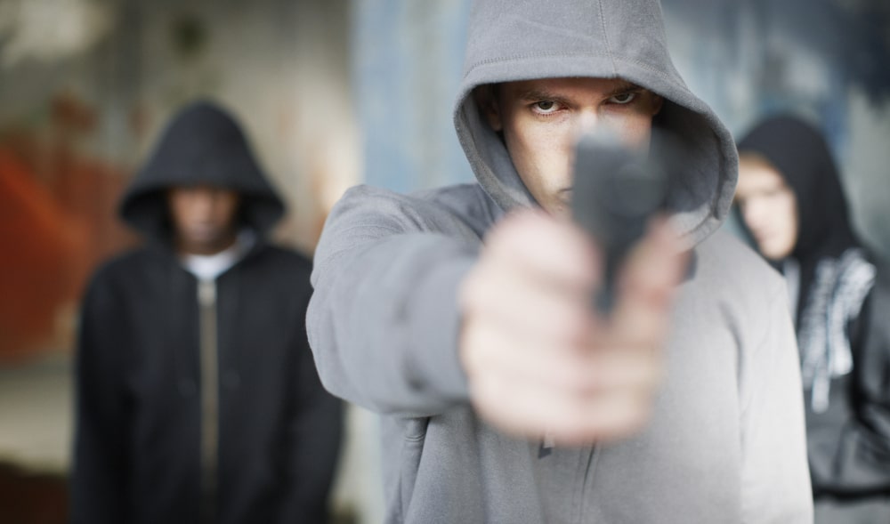 Navigating Youth Charges of Assault with a Weapon: Young Man with gun pointed at victim