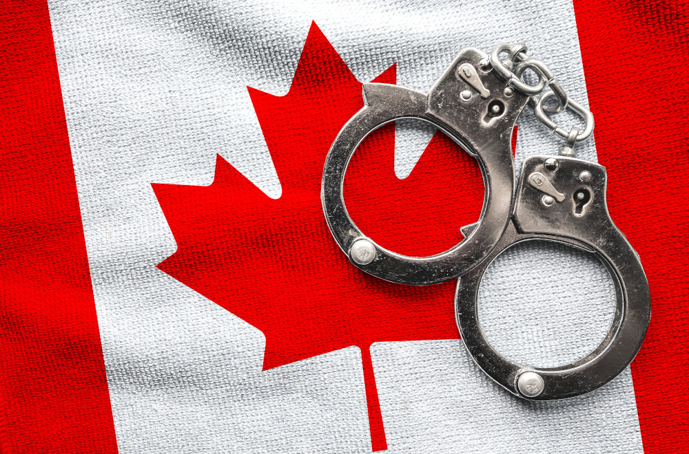 Flag of Canada and police handcuffs, symbolizing the serious nature of criminal offences in Canada and the confusion between felony and misdemeanour classifications.