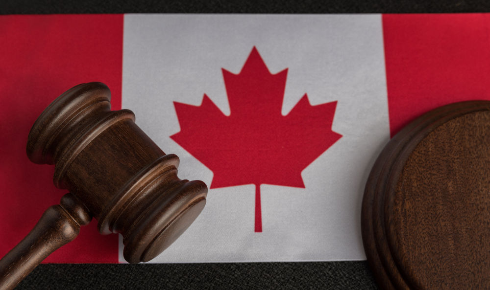 Judge gavel on a Canada flag, representing the Canadian criminal system's use of summary, indictable, and hybrid offences instead of felonies and misdemeanours.
